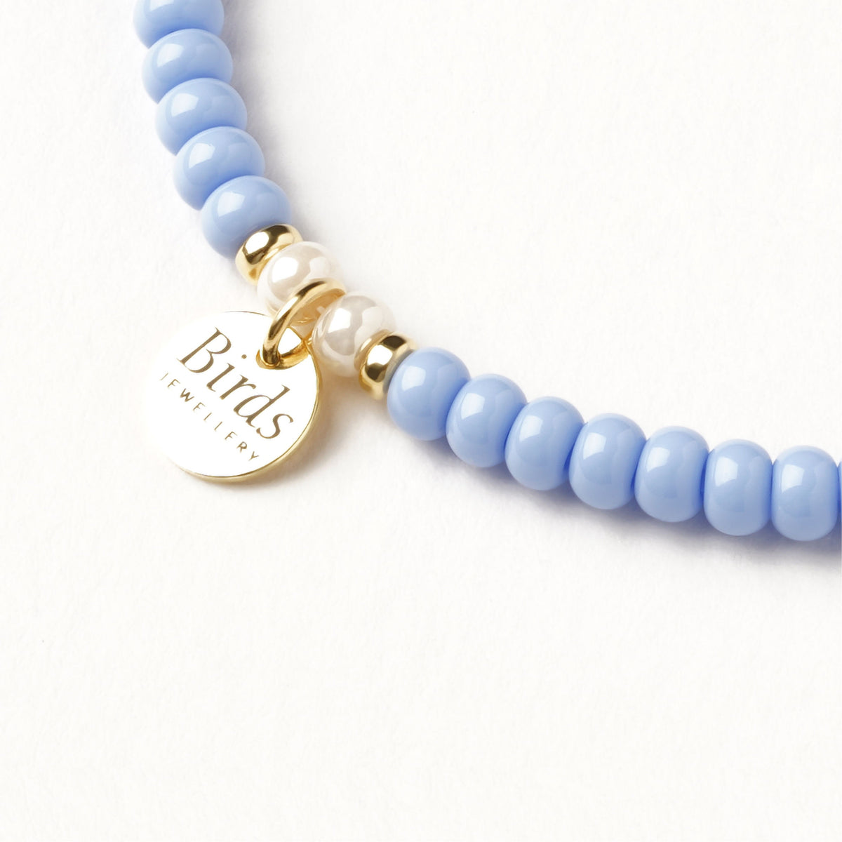 Detalhe da medalha em prata 925 da pulseira Azul Pastel & Marfim Perolado Birds Jewellery.