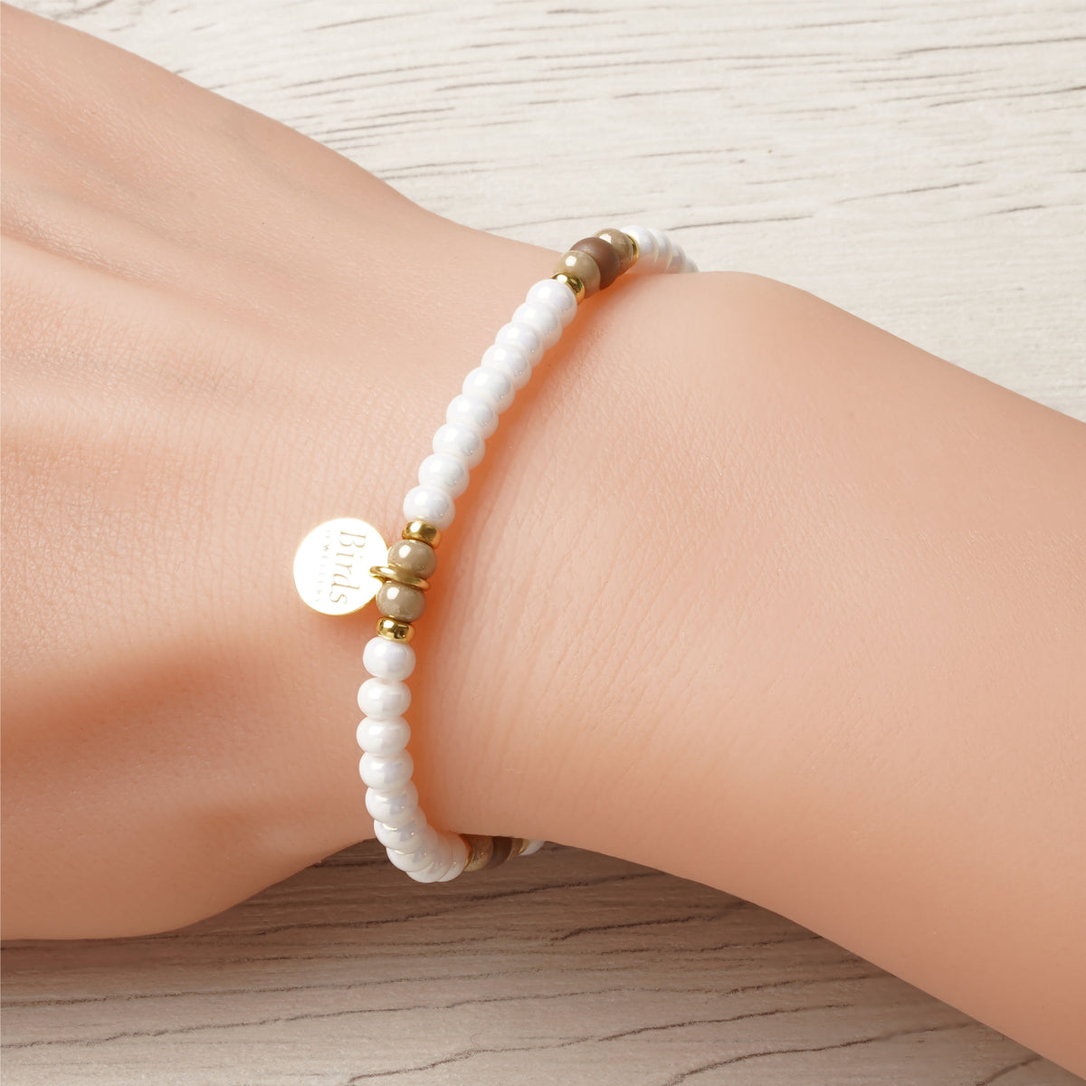 Pulseira Branco & Bege Vidrado em cristal boémio e prata 925 dourada ajustada no pulso feminino.