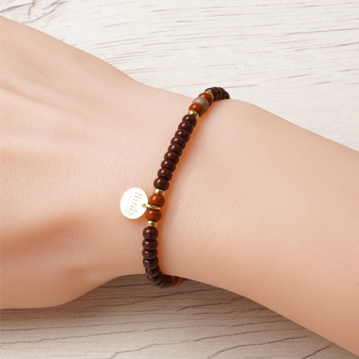 Pulseira Castanho Escuro & Bege Vidrado em cristal boémio e prata 925 dourada ajustada no pulso feminino.