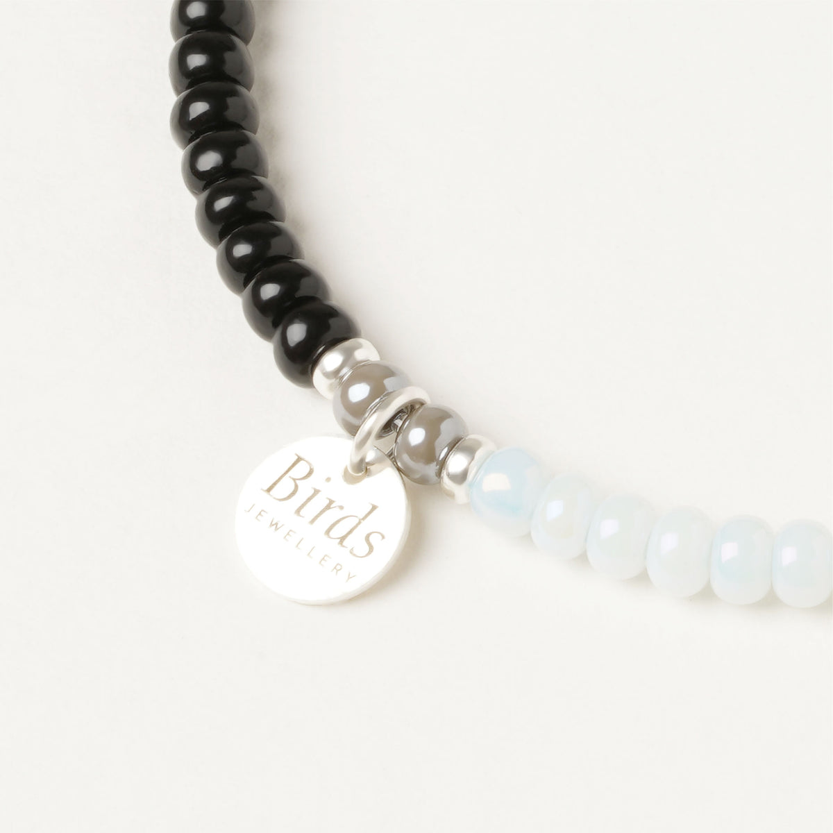 Detalhe da medalha em prata 925 da pulseira Preto, Água-Marinha & Cinzento Birds Jewellery.