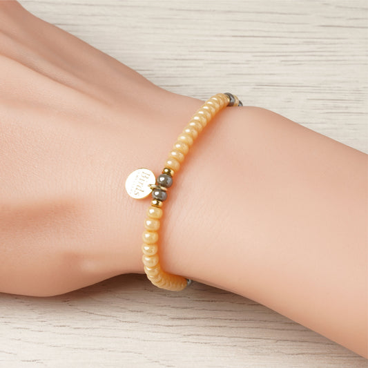 Pulseira Mel & Cinzento em cristal boémio e prata 925 dourada ajustada no pulso feminino.
