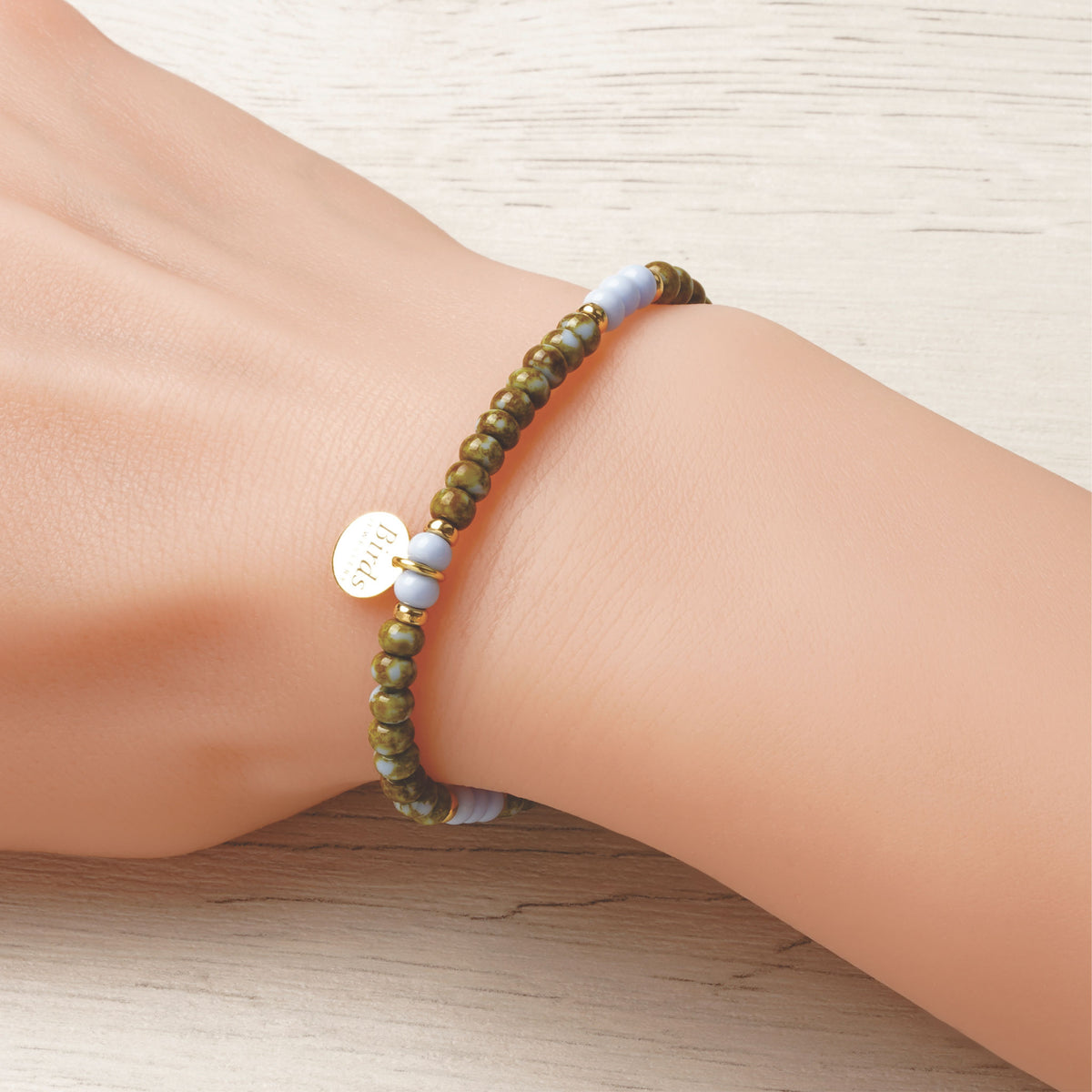 Pulseira Verde Azeitona & Azul Bebé em cristal boémio e prata 925 dourada ajustada no pulso feminino.