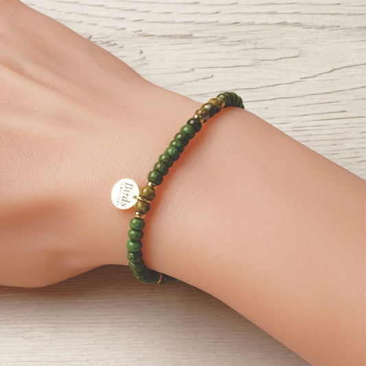 Pulseira Verde Alpino & Verde Azeitona em cristal boémio e prata 925 dourada ajustada no pulso feminino.